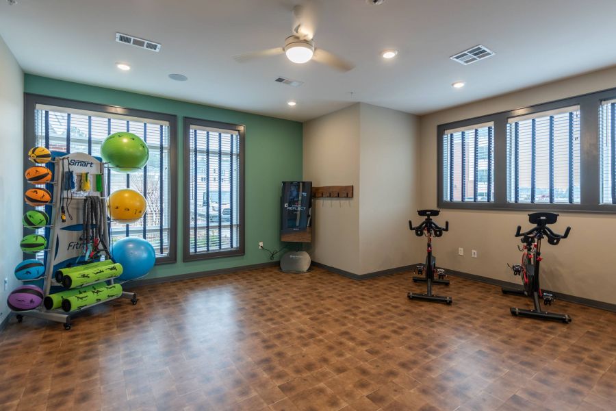 Attain at Harbour View luxury apartments with Small gym room with exercise balls, mats, and two stationary bikes near large windows.